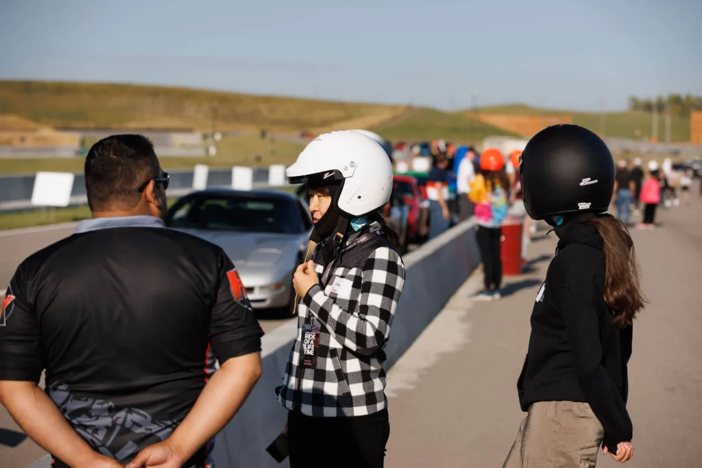 Kids in helmets waiting their turn at the track on event day
